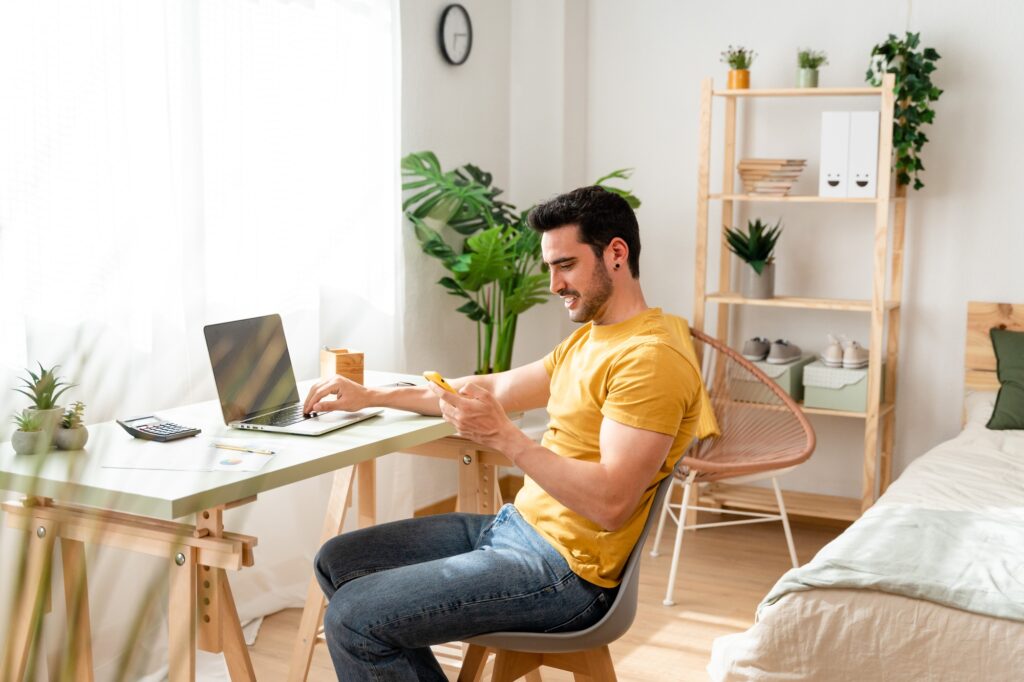 Optimistic man working with laptop from home.